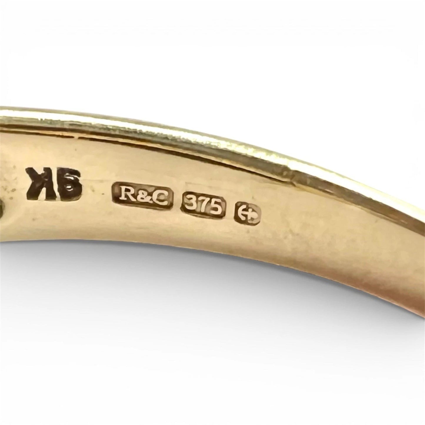 Gold ring with visible hallmarks on a white background