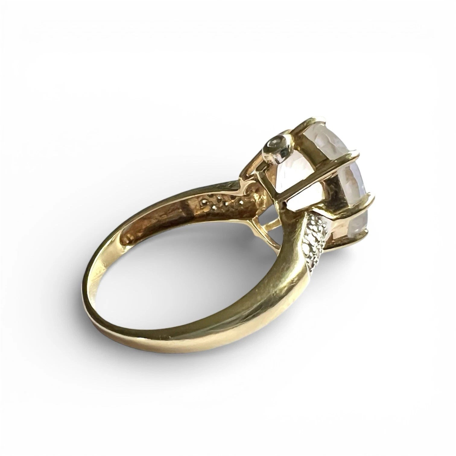 Gold ring with a large gemstone on a white background side view close up