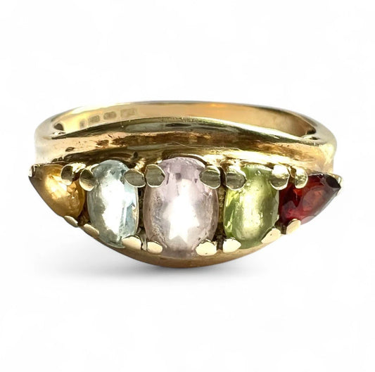 Gold ring with five coloured gemstones on a white background close-up front view 