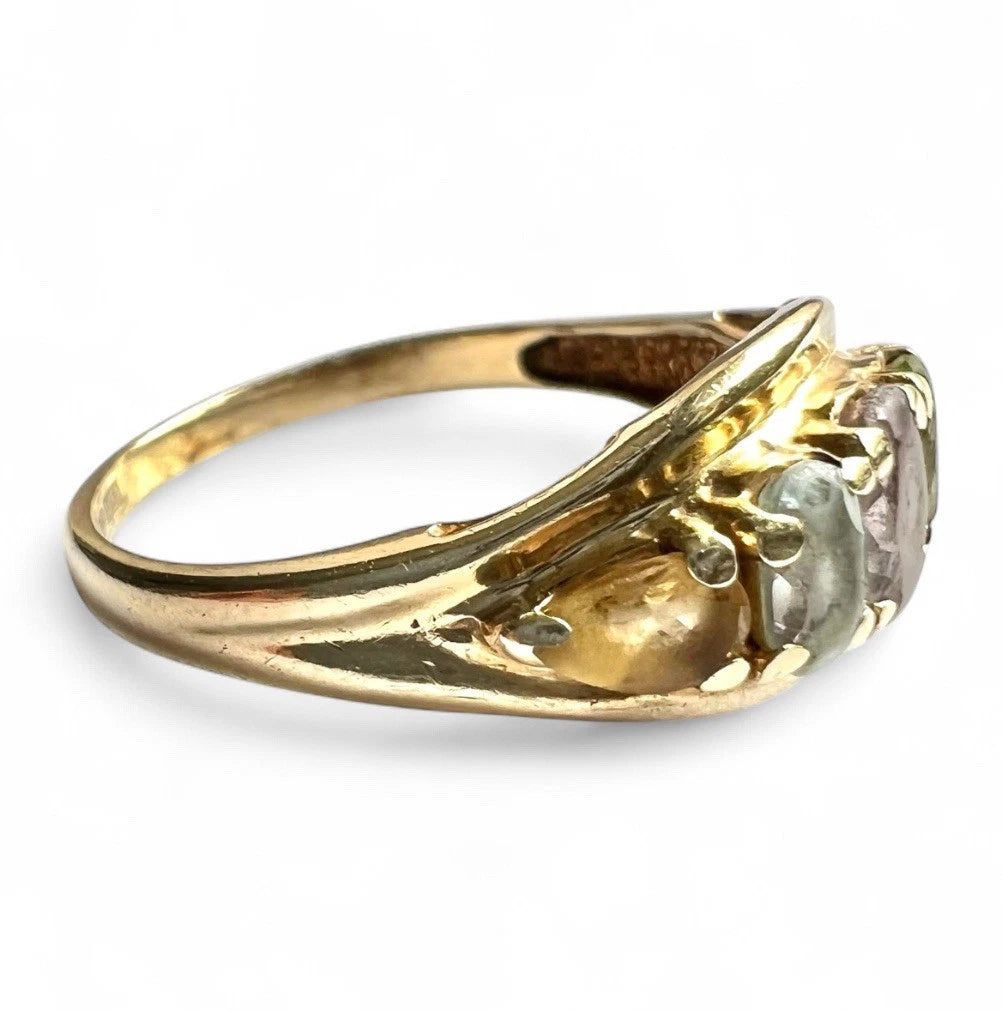 Gold ring with five multicoloured gemstone on a white background close-up side view 
