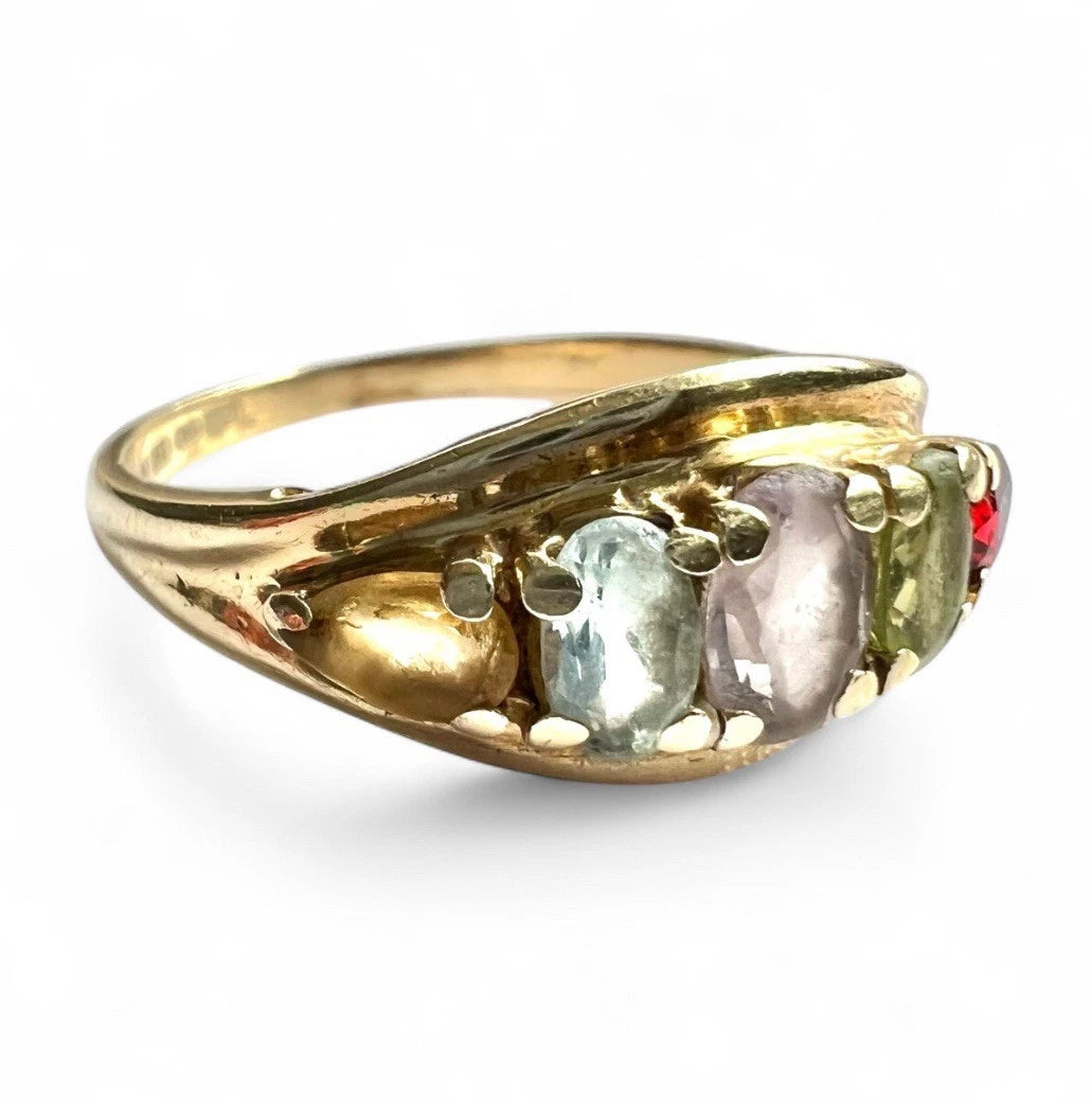 Gold ring with five gemstones on a white background close-up 
