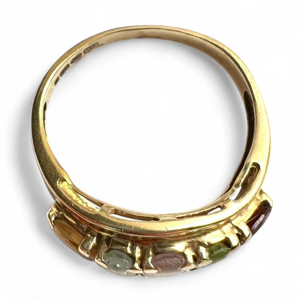 Gold ring with embedded gemstones on a white background close-up top down view 