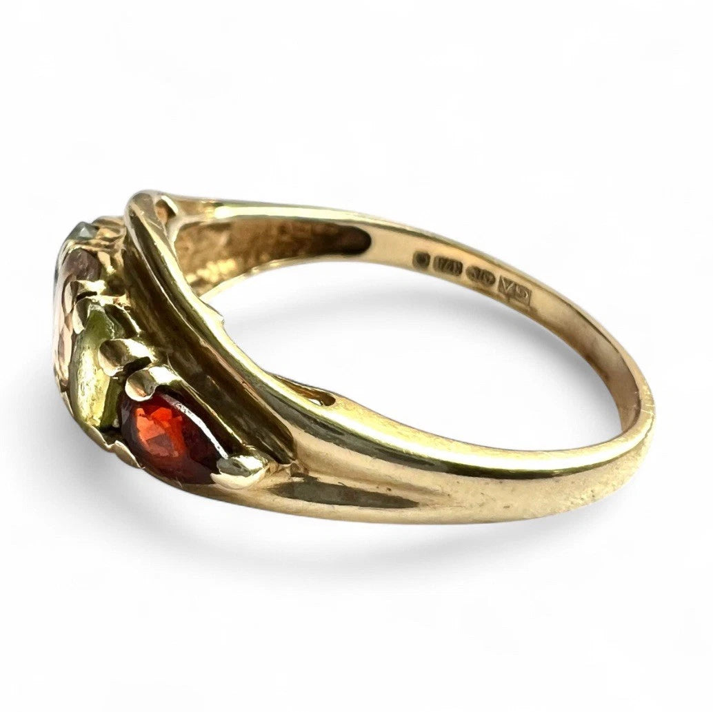 Gold ring with gemstones on a white background close-up side view 