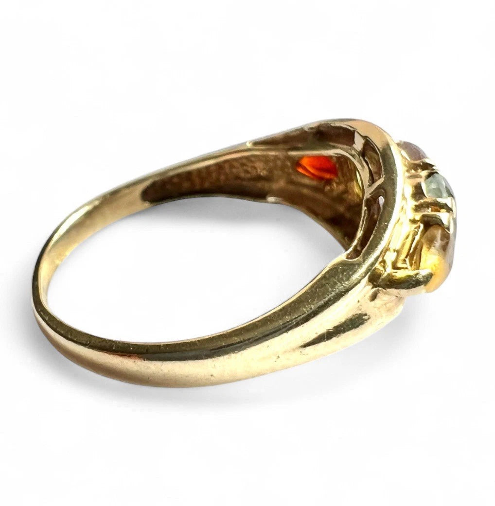 Gold ring with gemstones on a white background close up side view 