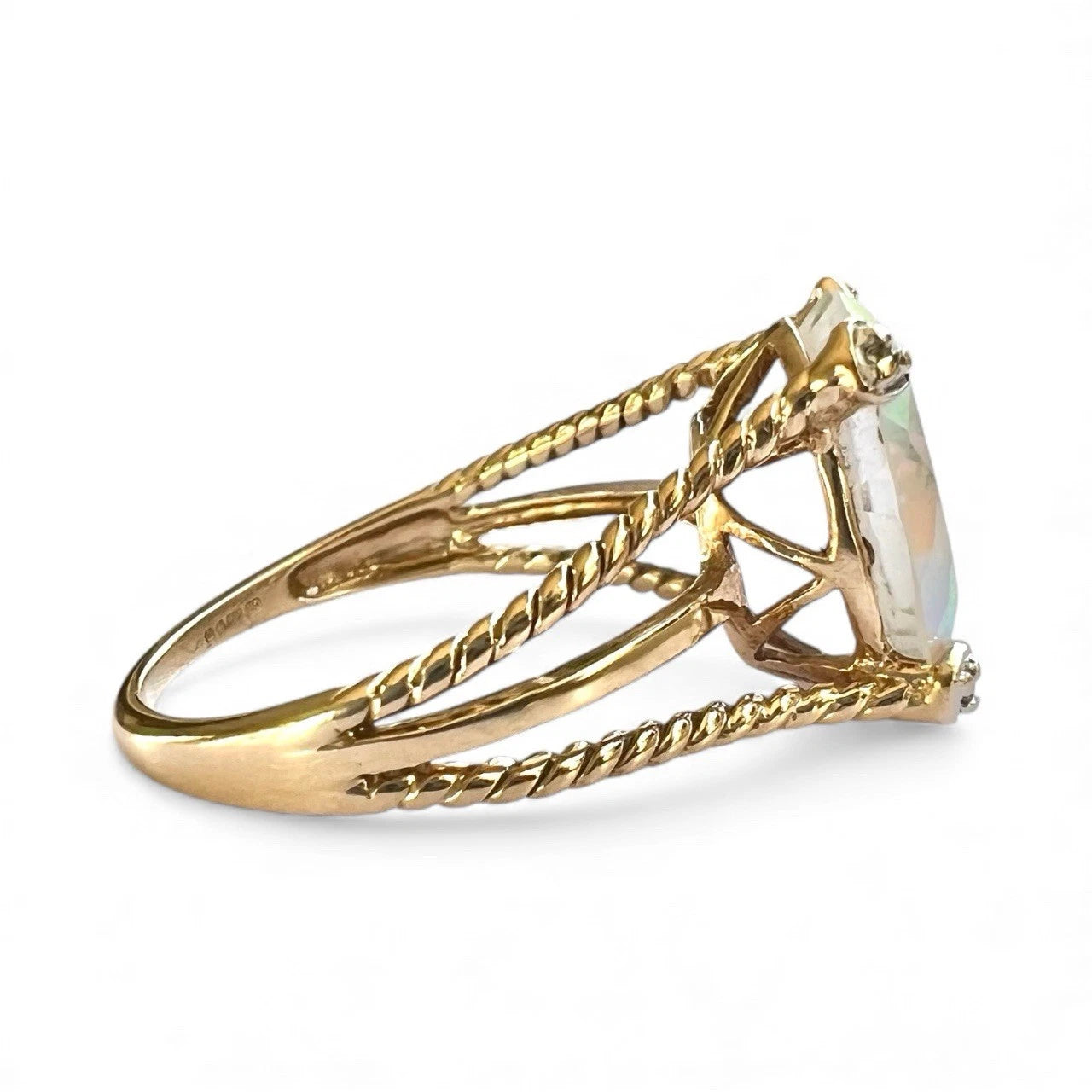 Gold ring with a mystic quartz gemstone on a white background closeup side view 