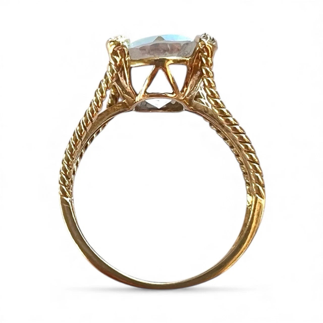 Gold ring with a central mystic quartz gemstone on a white background