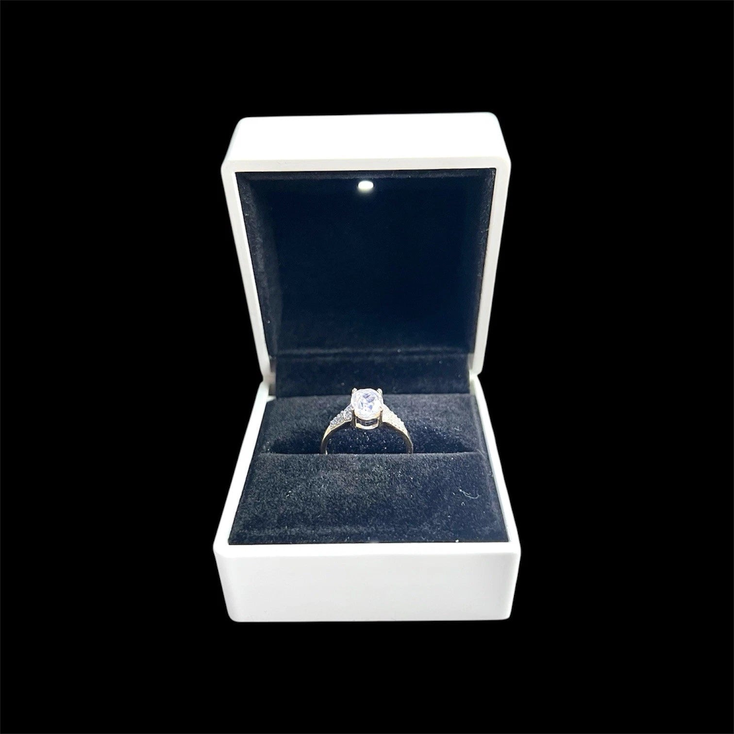 Quartz and diamond ring in a white box with a black background