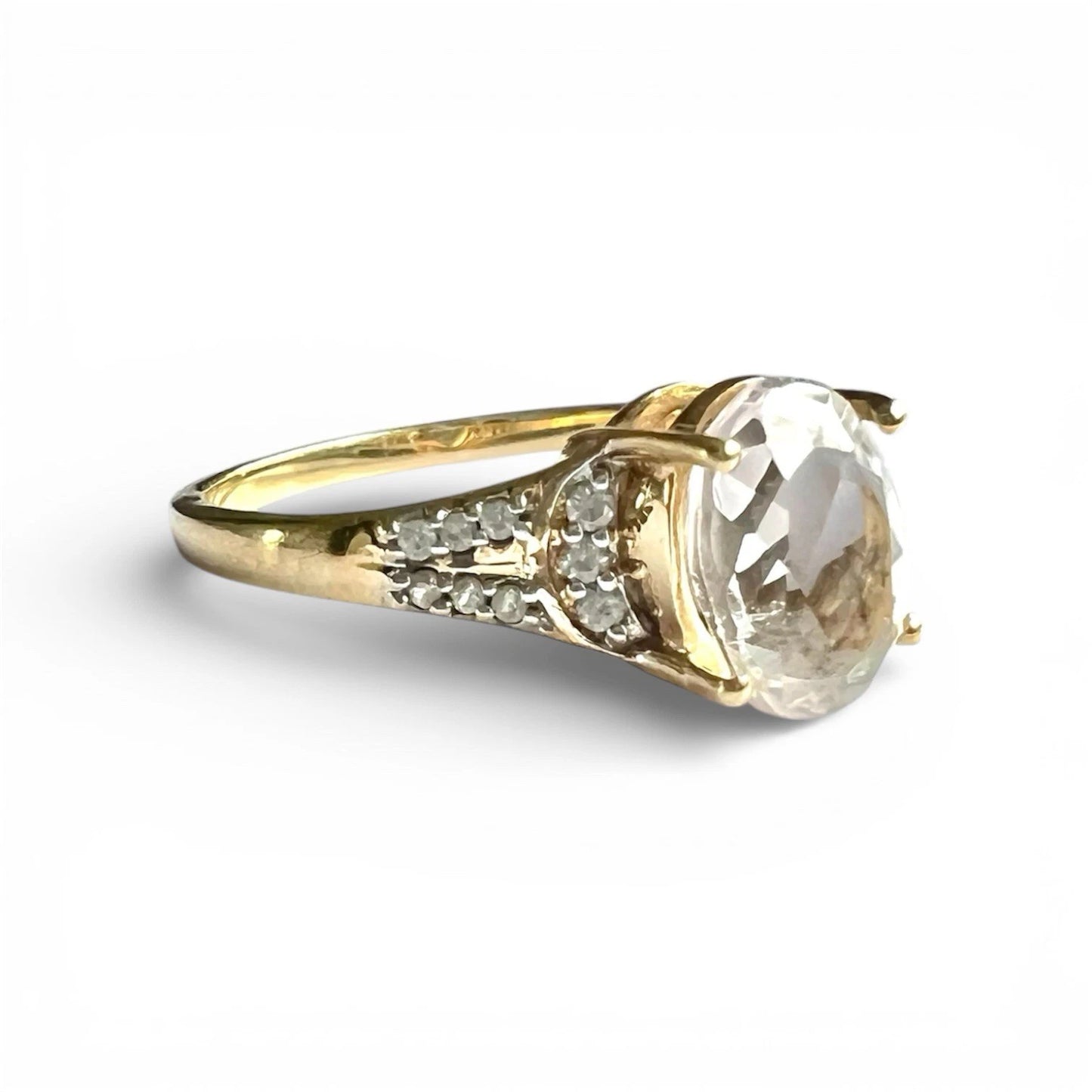 Gold ring with a large quartz and diamonds on a white background