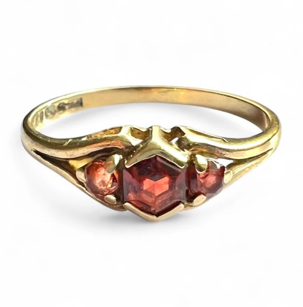 Gold ring with red gemstones on a white background
