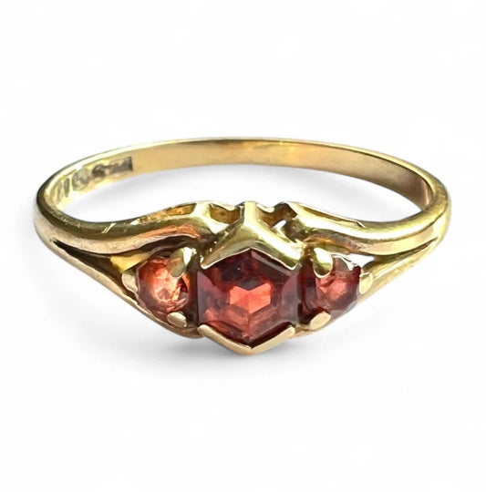 Gold ring with red gemstones on a white background