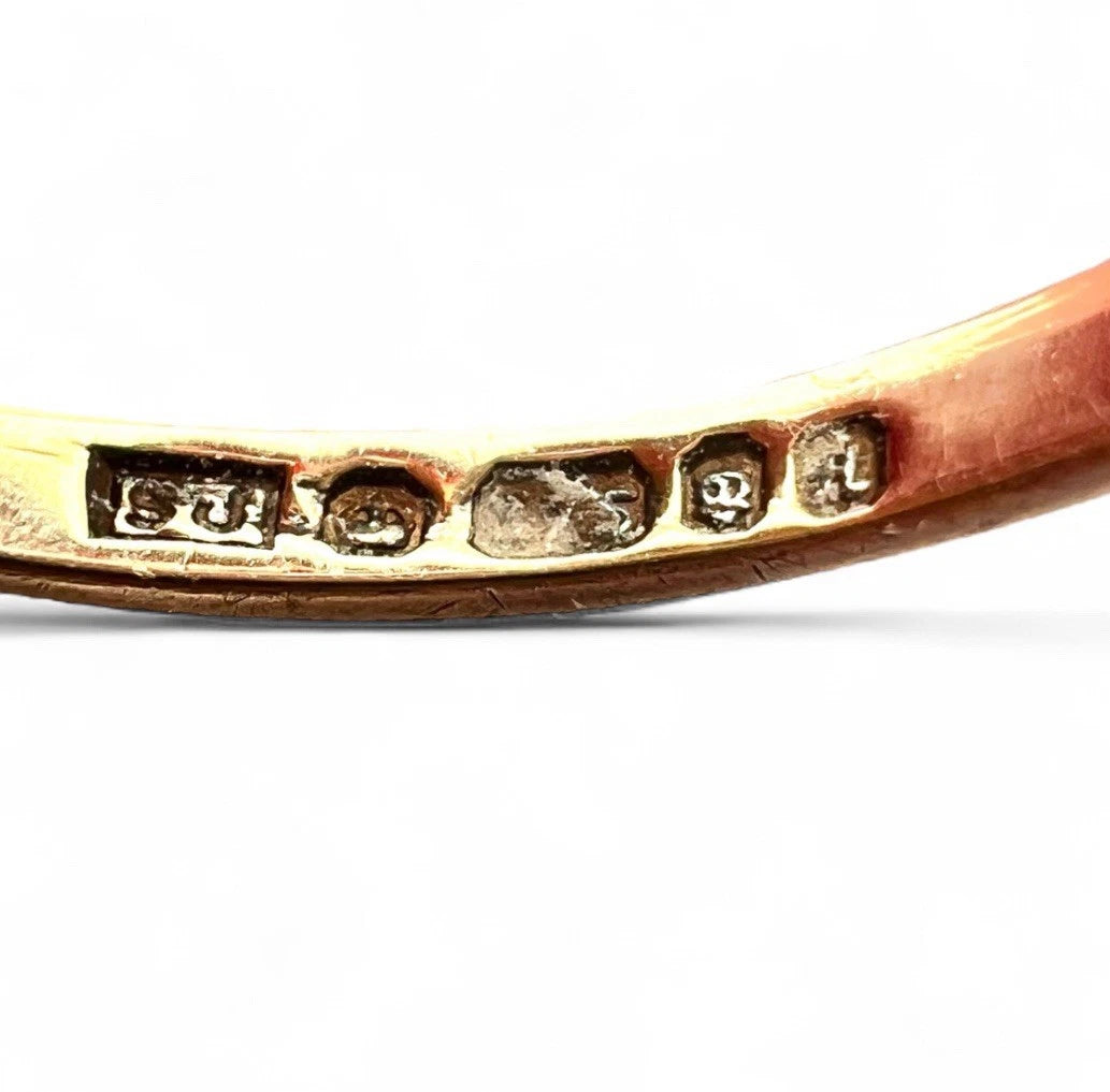 Close-up of a gold ring with embedded stones on a white background