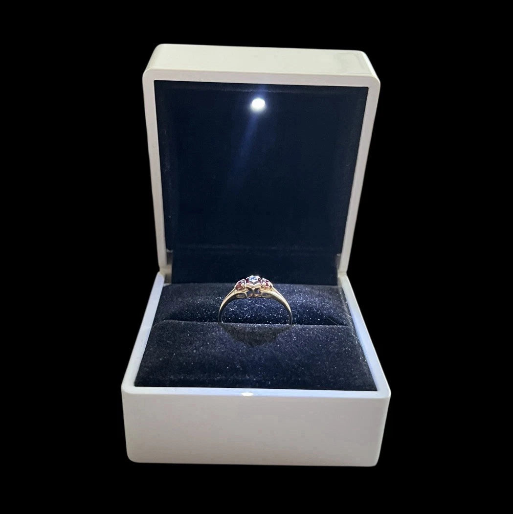 Gold ring in a white box with a black interior