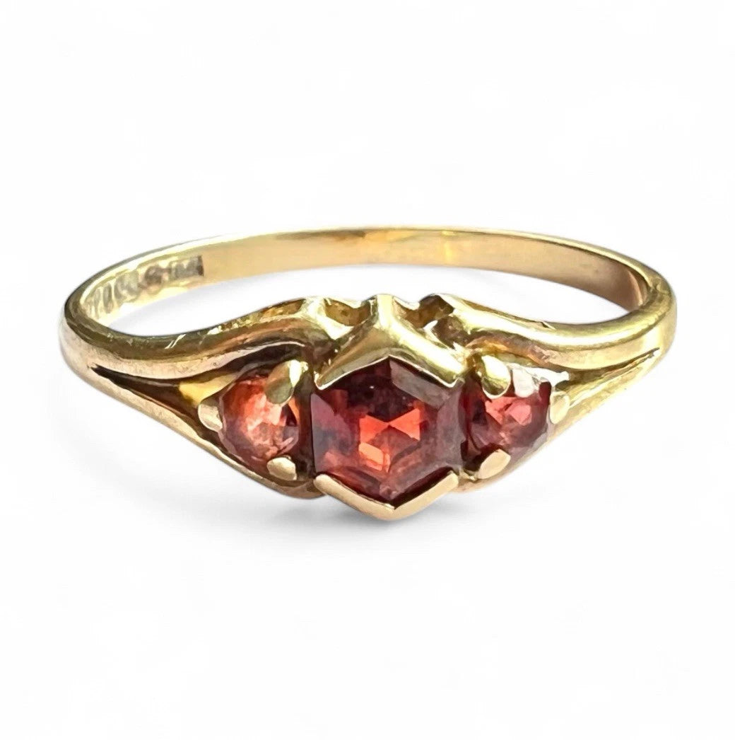 Gold ring with red gemstones on a white background