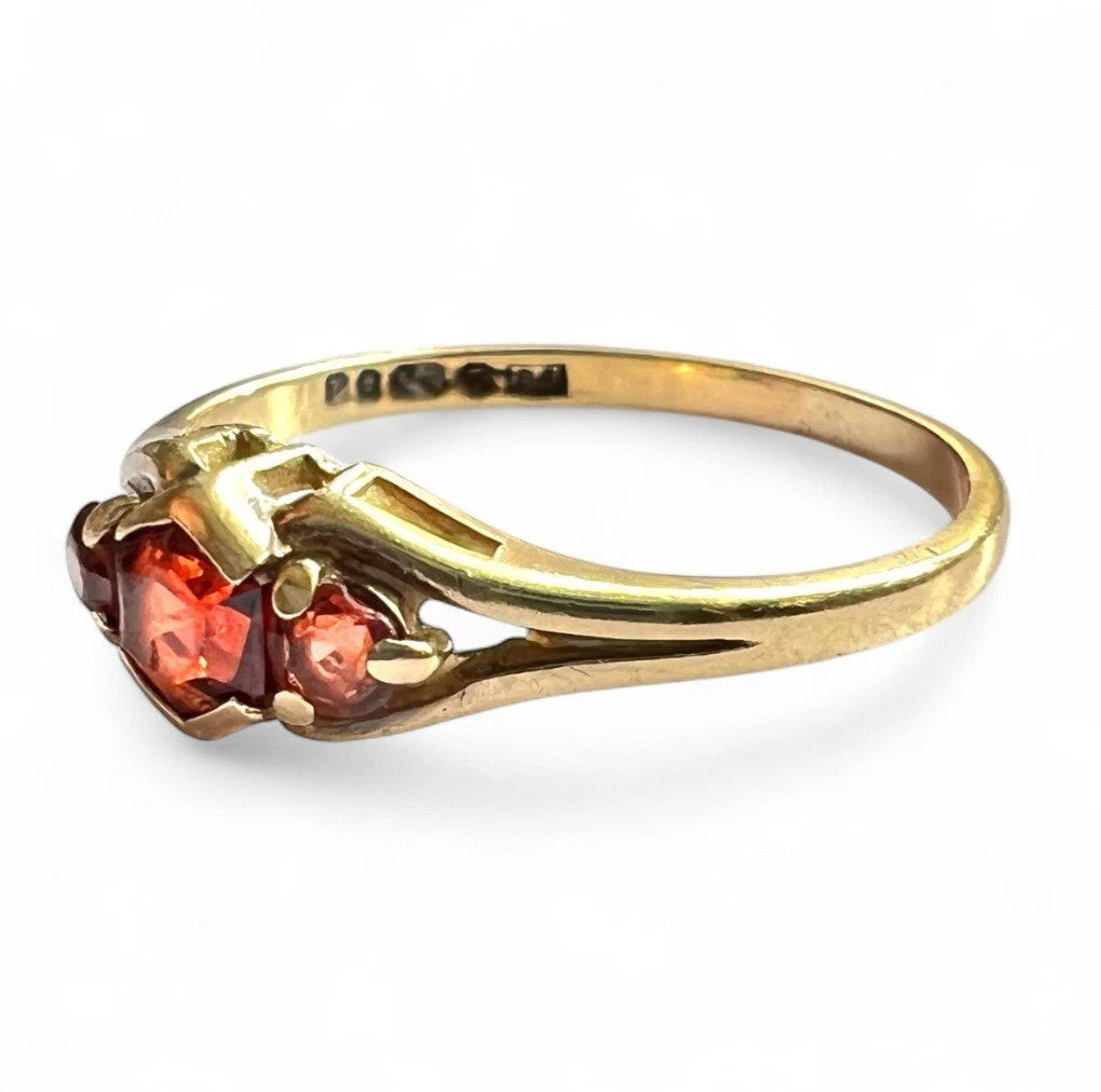 Gold ring with red gemstones on a white background