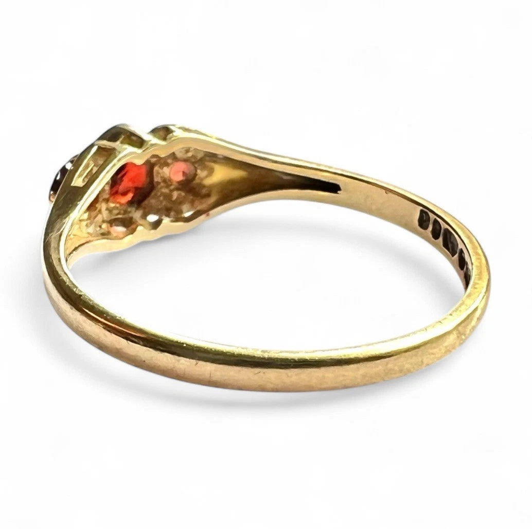 Gold ring with red gemstones on a white background