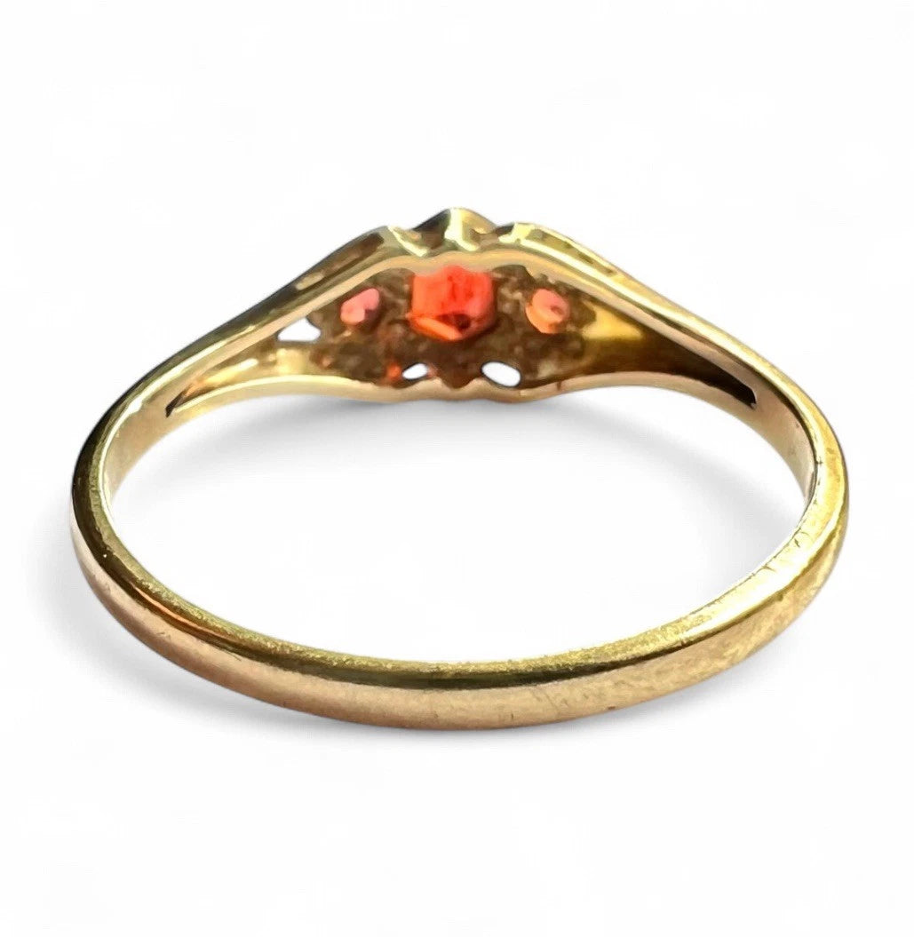 Gold ring with red gemstones on a white background