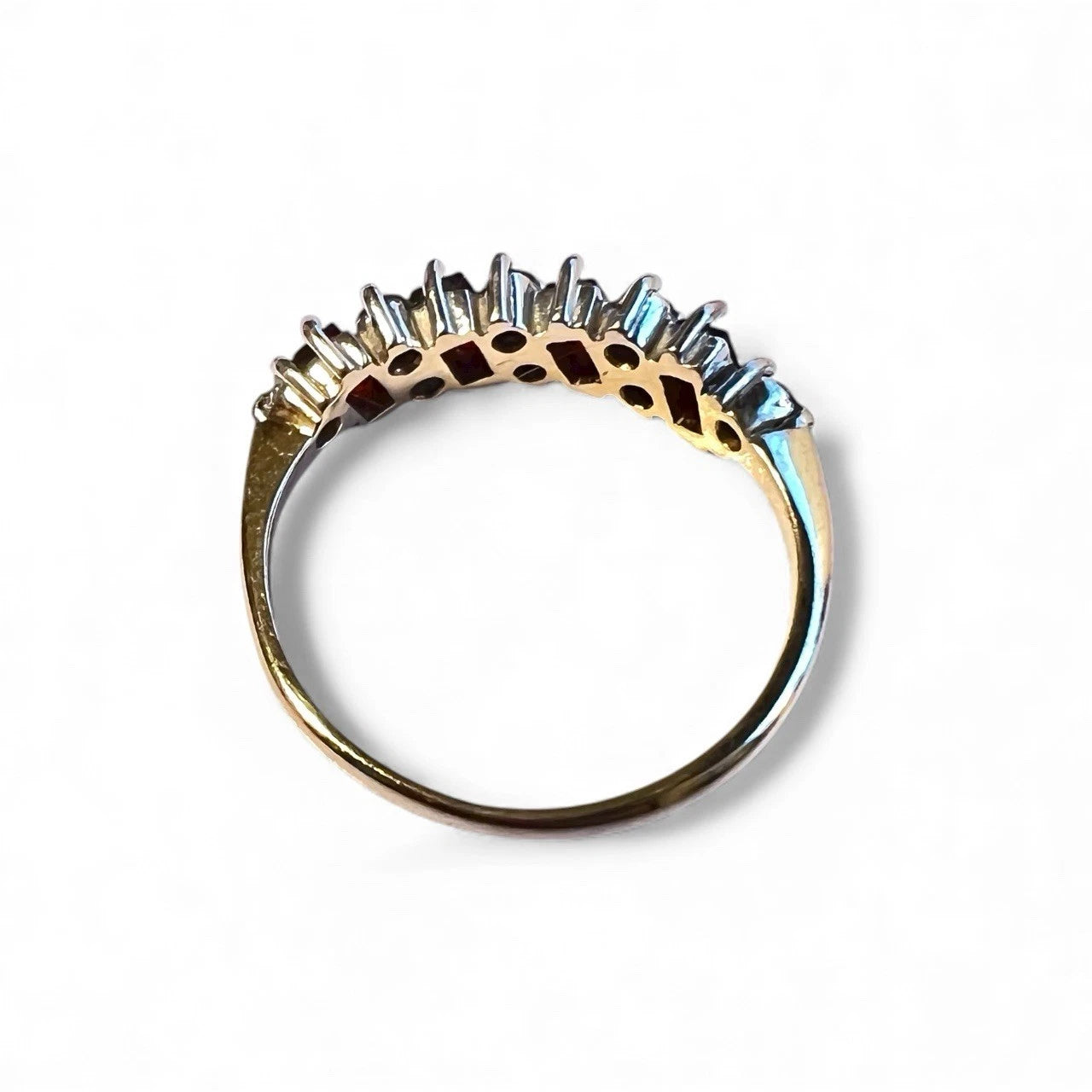 Gold ring with diamond-like stones on a white background