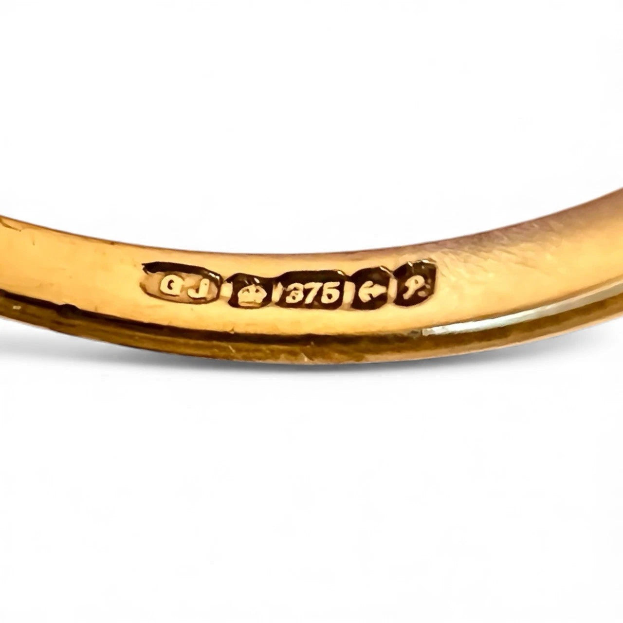 Gold ring with visible hallmark on a white background