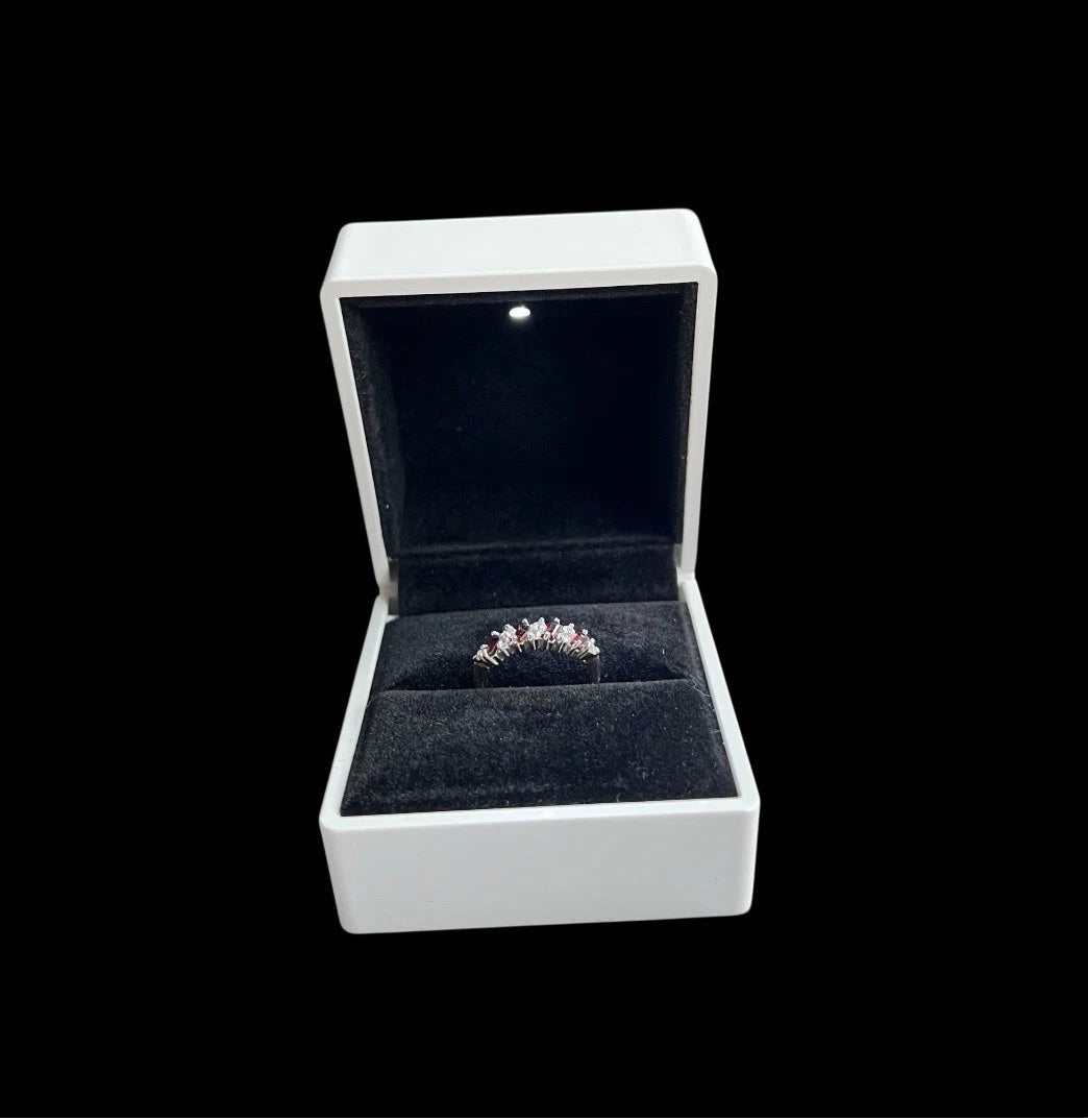 Open jewellery box with a ring inside on a black background