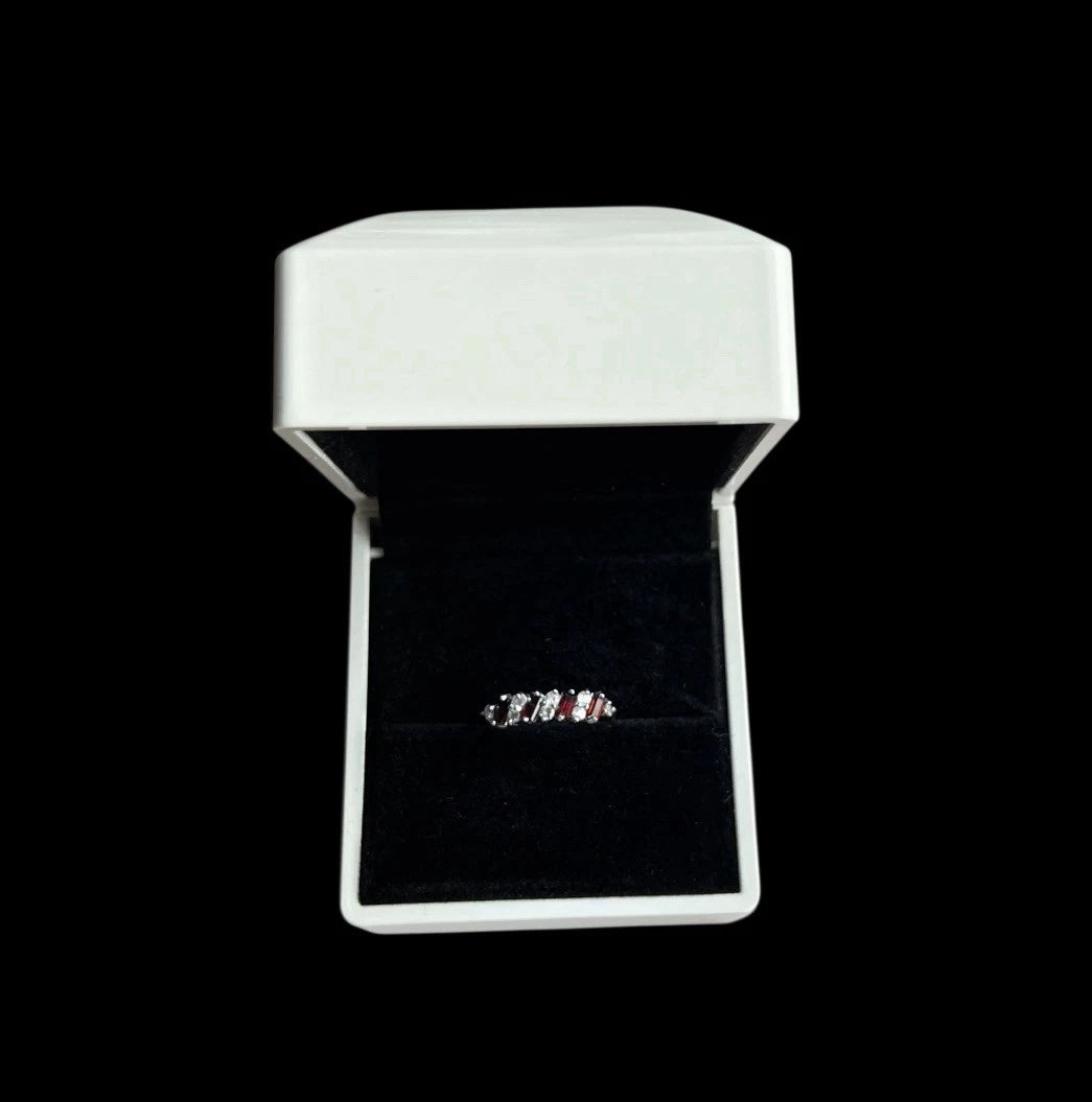 Gold ring with alternating red and clear CZ in a white box on a black background