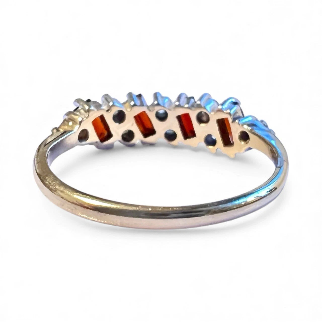 Ring with gemstones on a white background. Close up rear view 