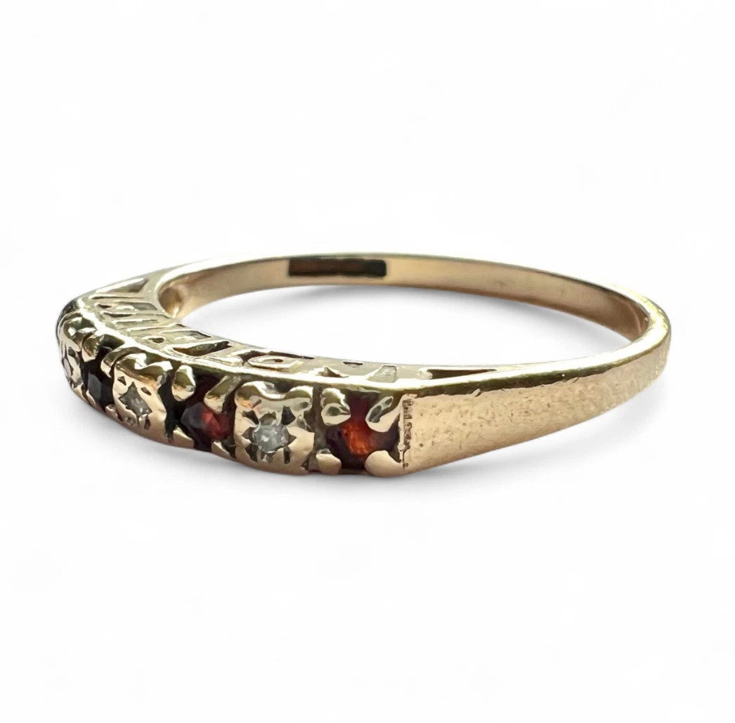 Gold ring with embedded ruby and CZ on a white background