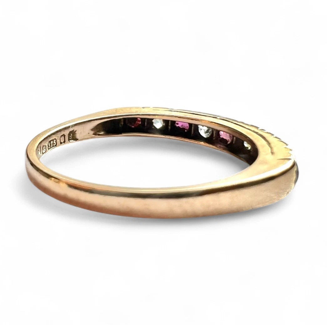 Gold ring with ruby and CZ gemstones on a white background close up side view 