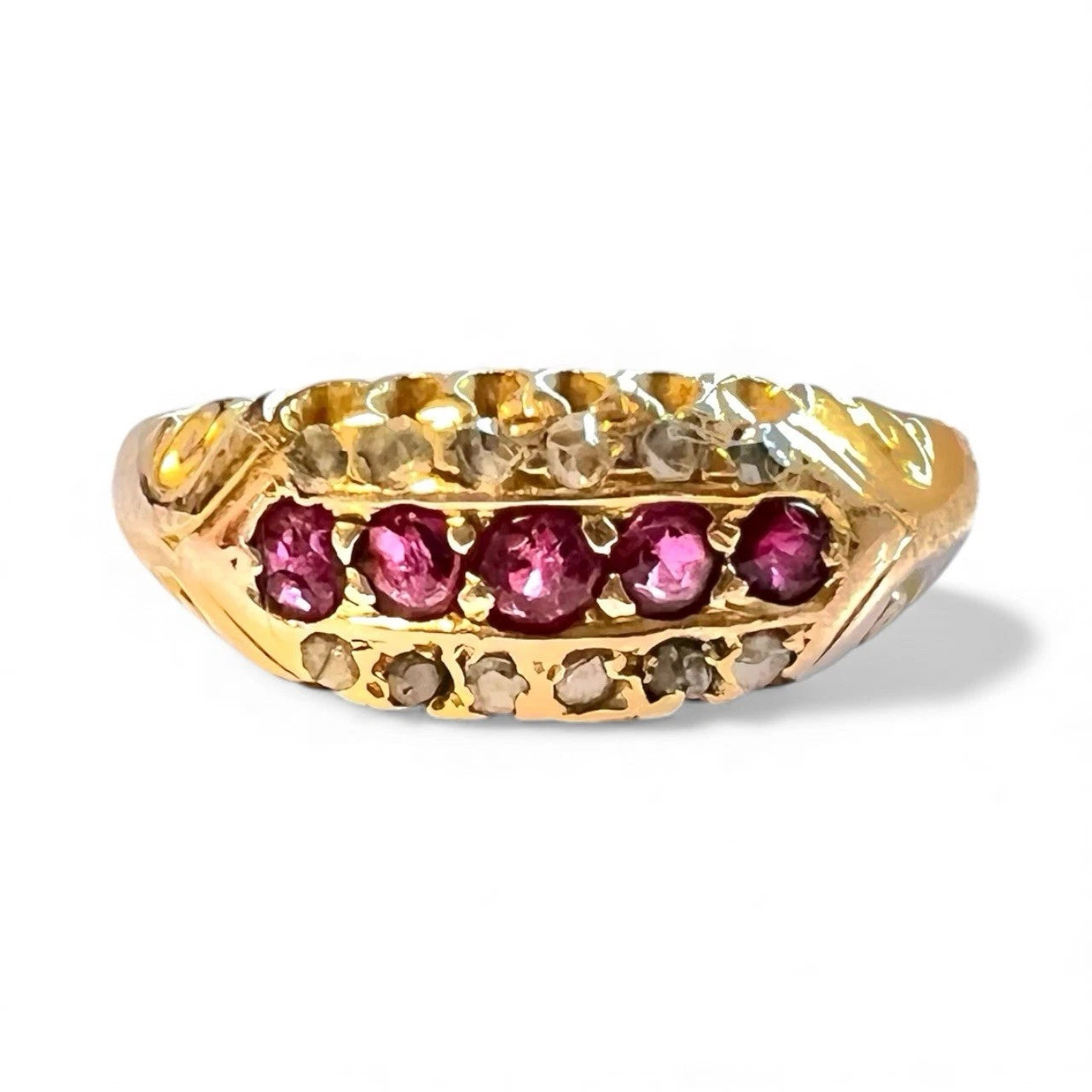 Antique gold ring with red rubies and diamond gemstones on a white background close up front view 