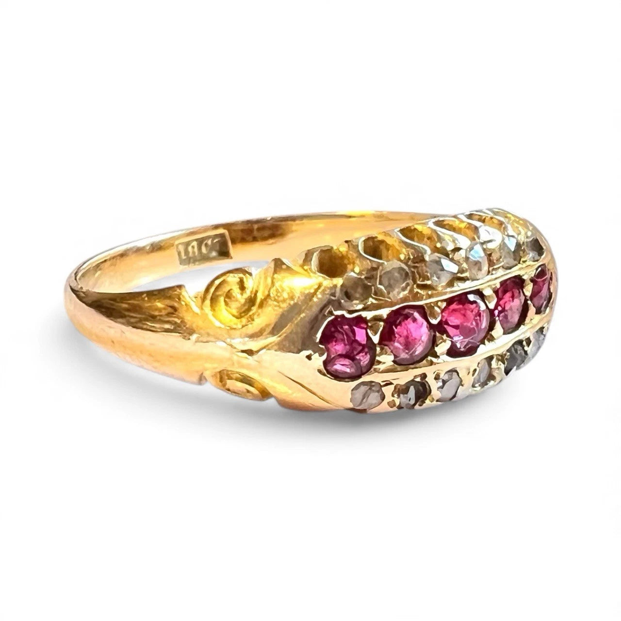Edwardian gold ring with red ruby and diamond gemstones on a white background close up 