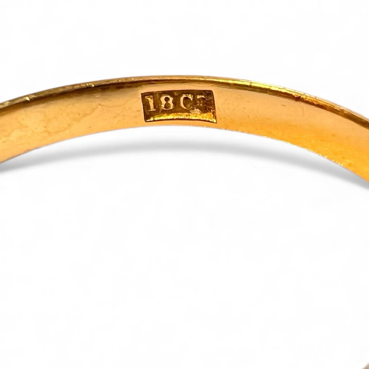 Gold ring with '18K' hallmark on a white background