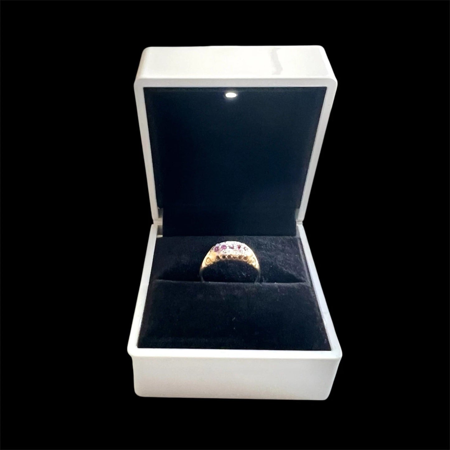 Gold ring in a white box with a black interior