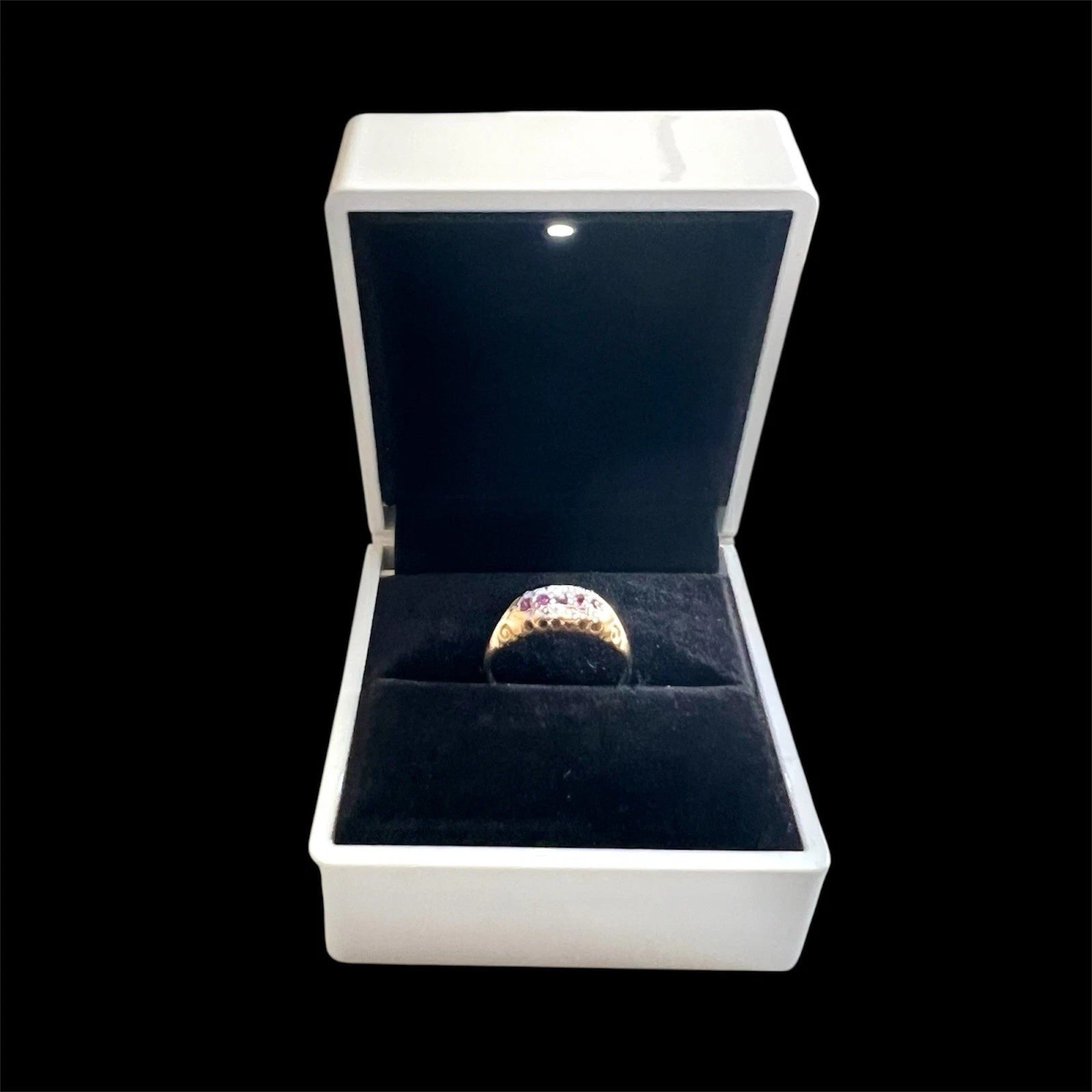Gold ring in a white box with a black interior