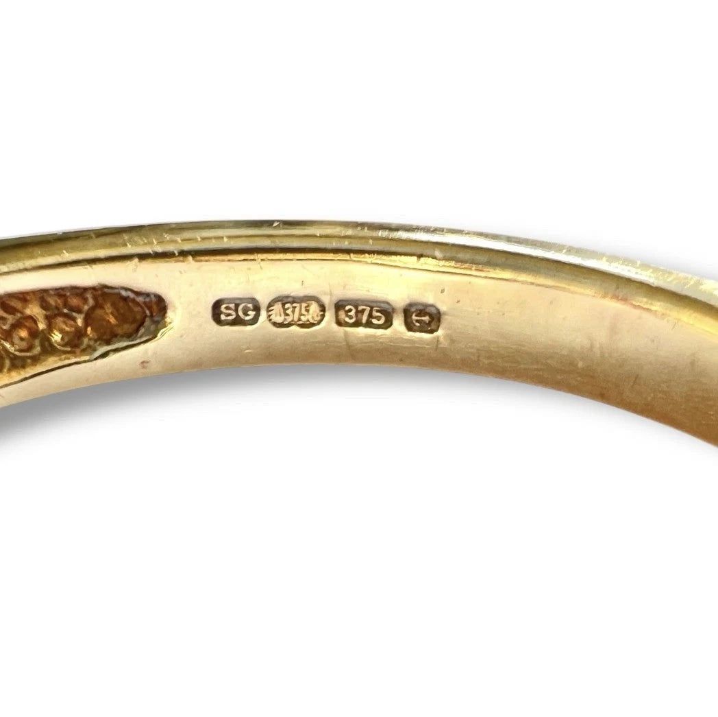 Gold ring with visible hallmarking on a white background