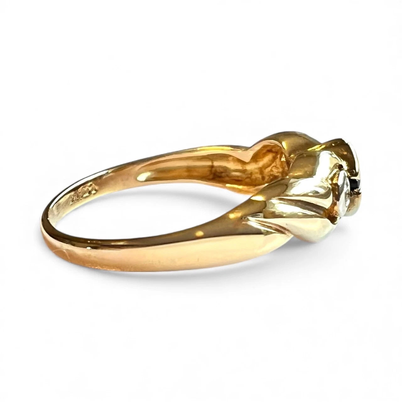 Gold ring with a blue sapphire and two diamonds on a white background, close up side view 