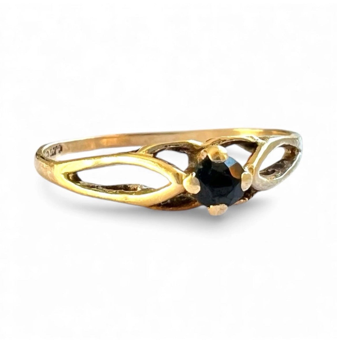 Gold ring with a black gemstone on a white background