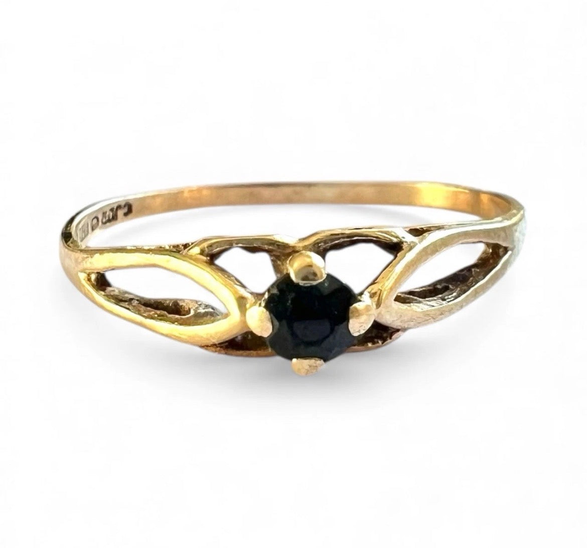 Gold ring with a black gemstone on a white background