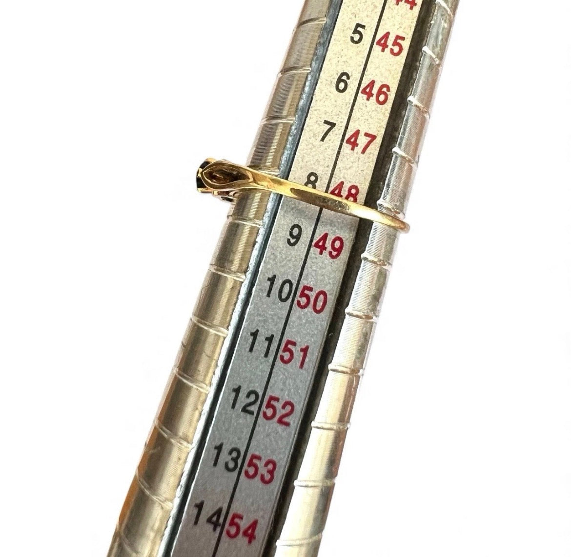 Close-up of a silver measuring gauge with gold ring on a white background
