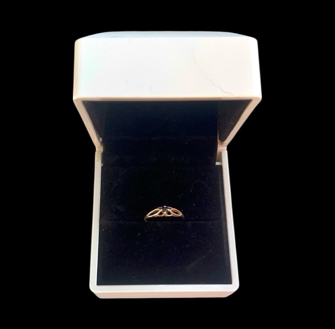 Gold ring in a white box with a black interior
