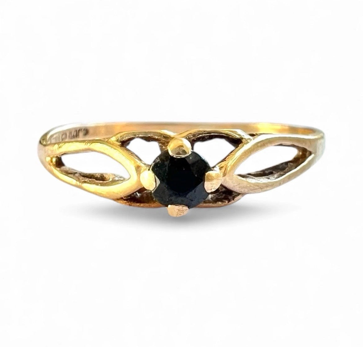 Gold ring with a sapphire gemstone on a white background