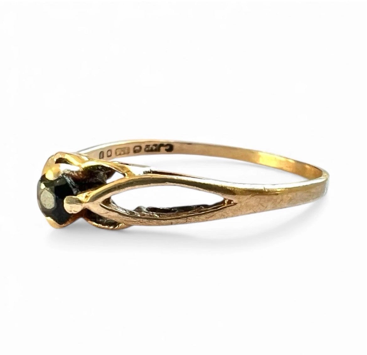 Gold ring with a sapphire gemstone on a white background