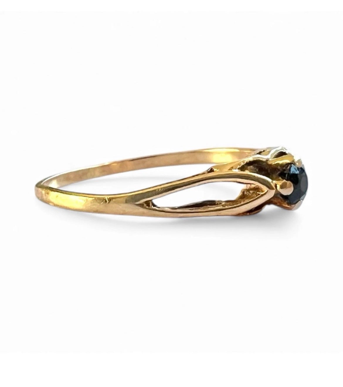 Gold ring with a black gemstone on a white background
