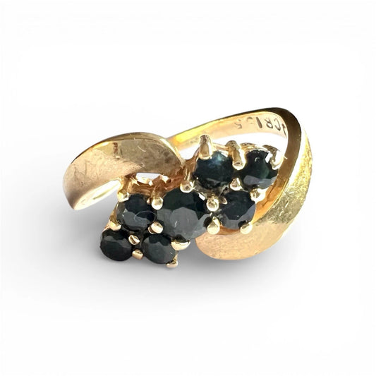 Gold ring with sapphire gemstones on a white background