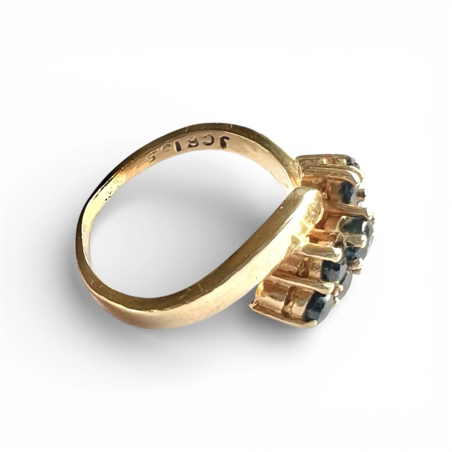 Gold ring with sapphire gemstones on a white background