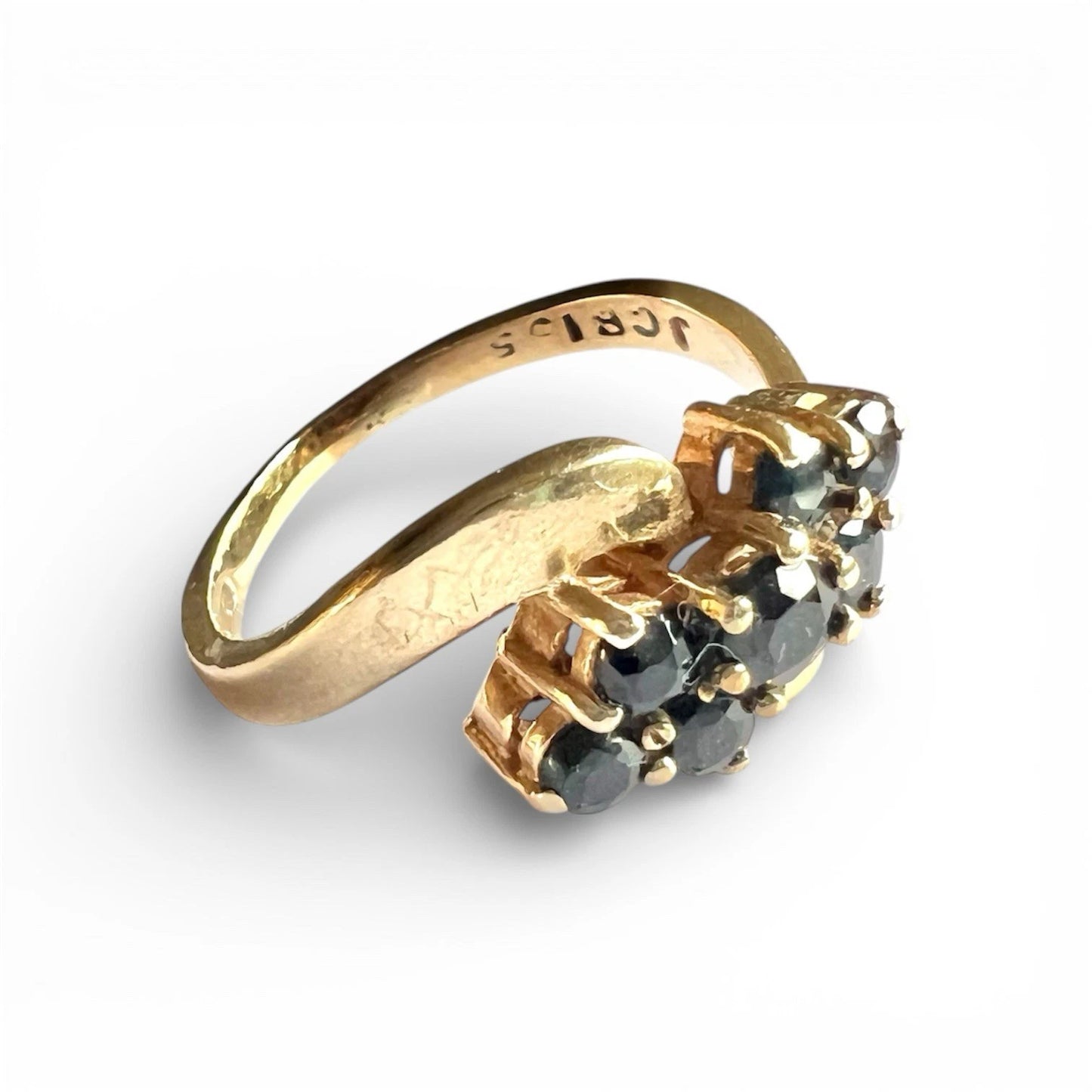 Gold ring with sapphire gemstones on a white background