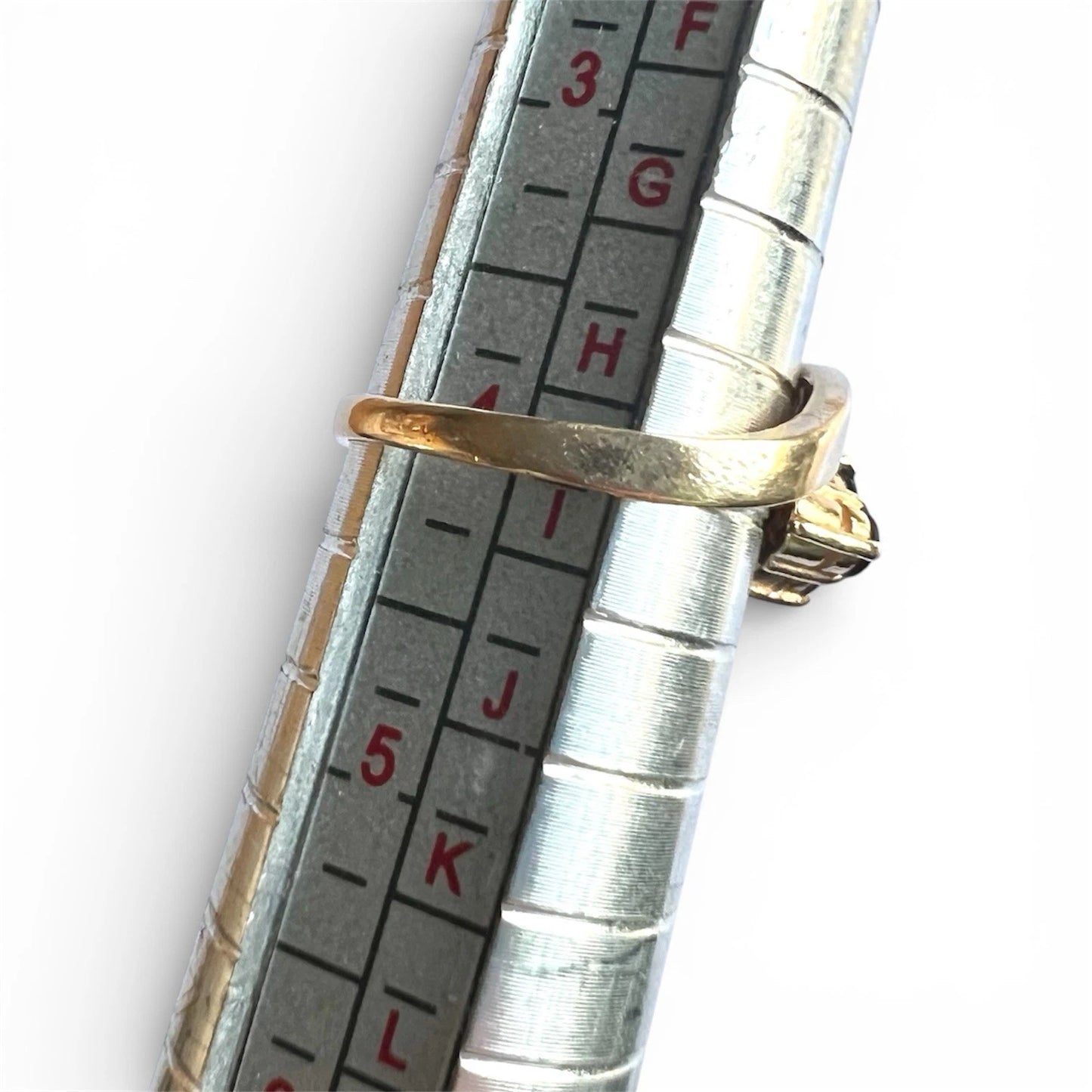Gold ring on a silver measuring tool with measurement scale