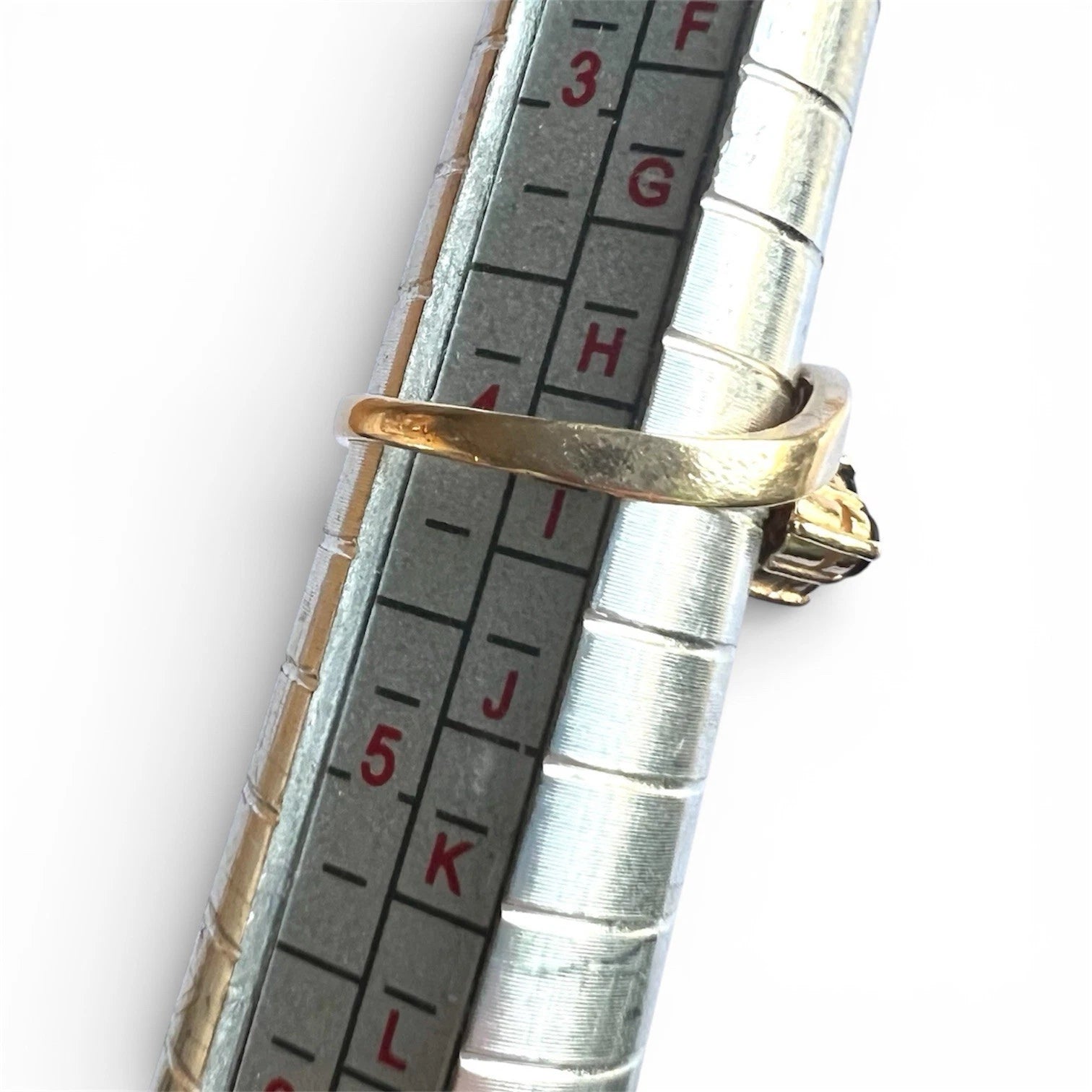 Gold ring on a silver measuring tool with measurement scale