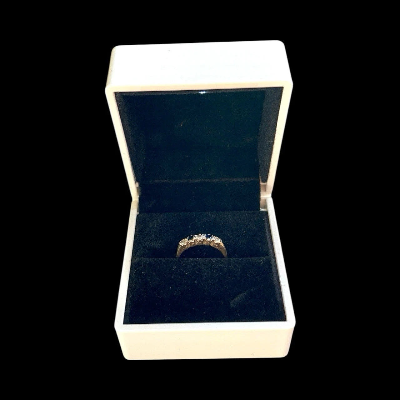 Gold ring in an open jewellery box on a black background
