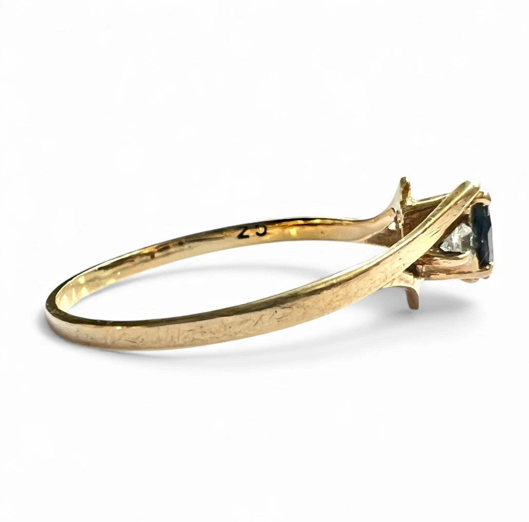 Gold ring with a sapphire gemstone on a white background