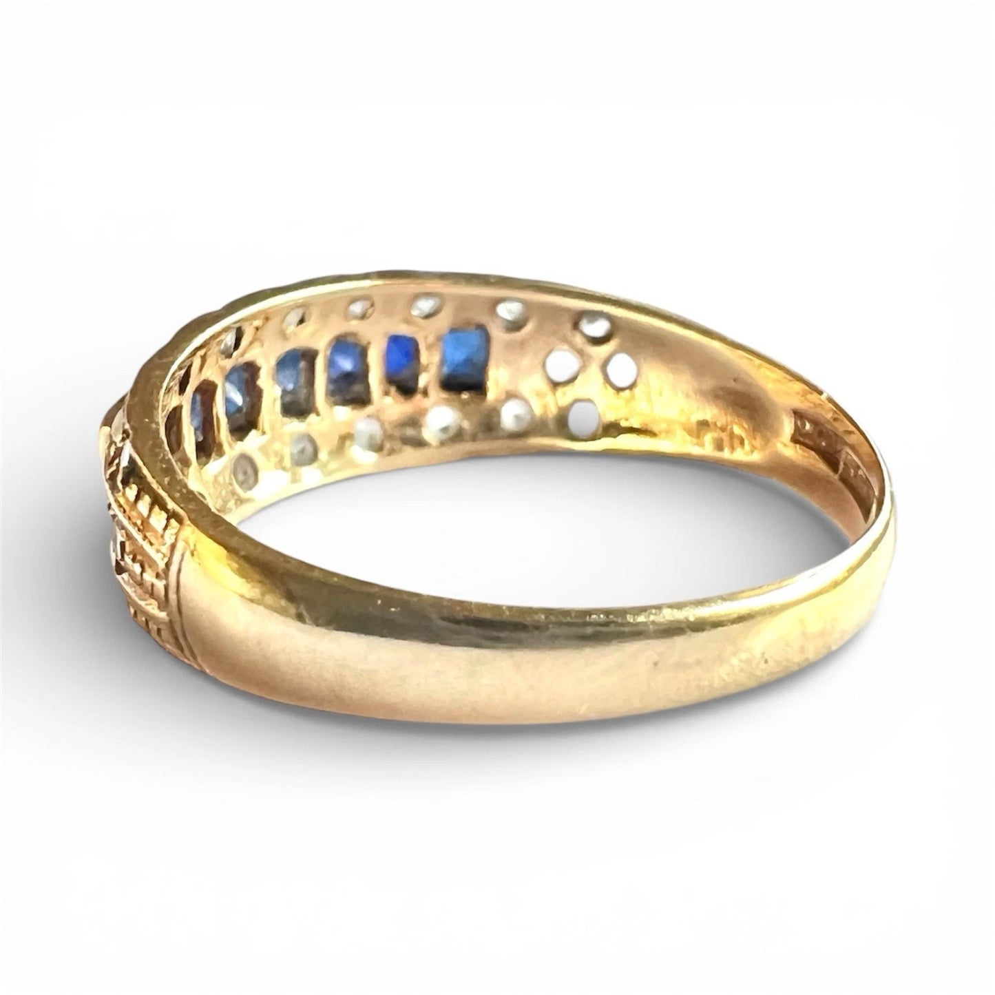Rear view of gold ring with embedded stones on a white background