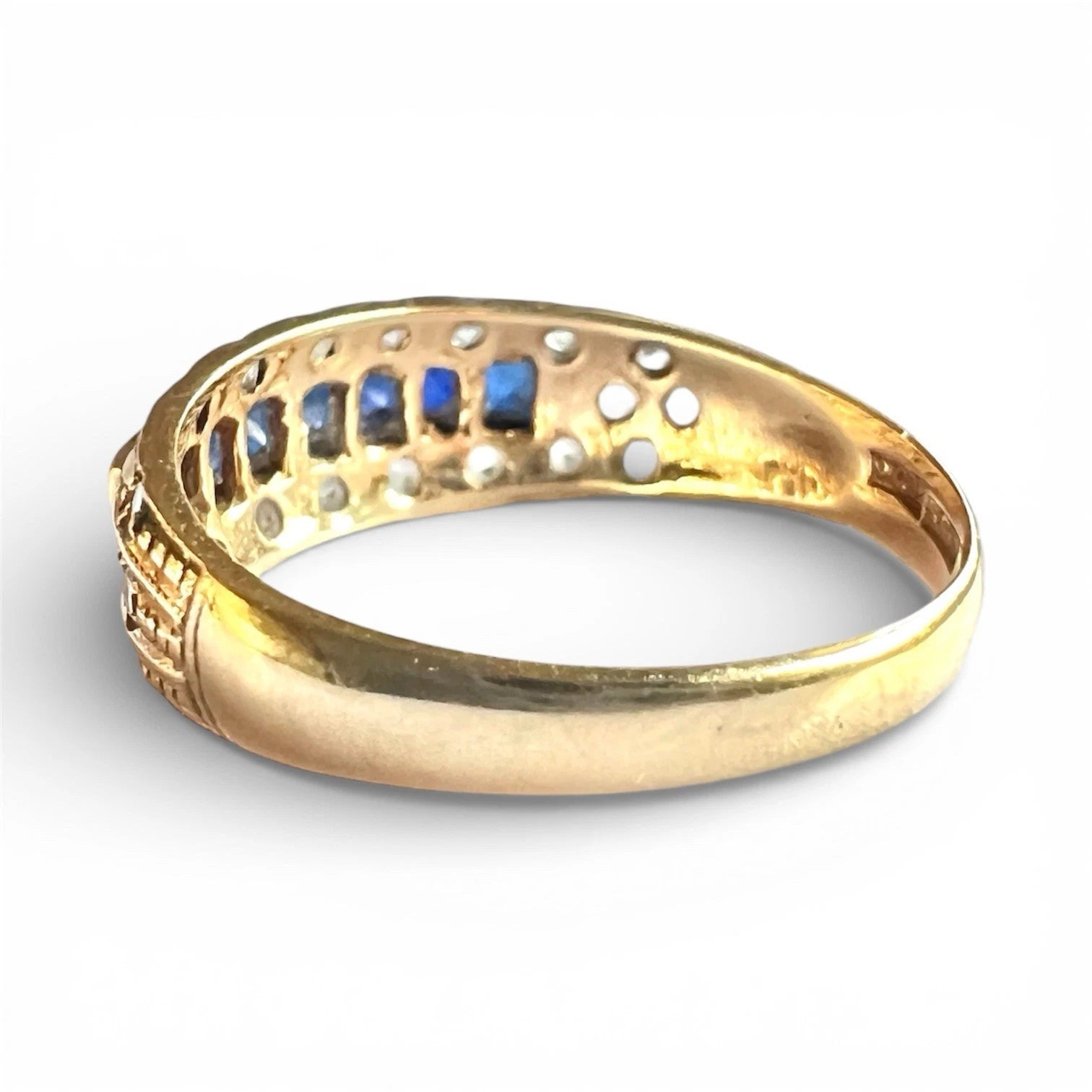 Rear view of gold ring with embedded stones on a white background
